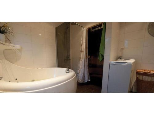 y baño con bañera blanca y ducha. en Svinö Waterfront Villa, en Lumparland