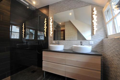 a bathroom with two sinks and a mirror at Appartement Grenier à sel Gentleman in Colmar