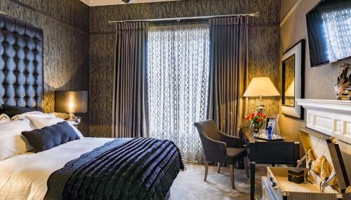 Pokój hotelowy z łóżkiem, biurkiem i oknem w obiekcie Ram Lodge w mieście Moffat