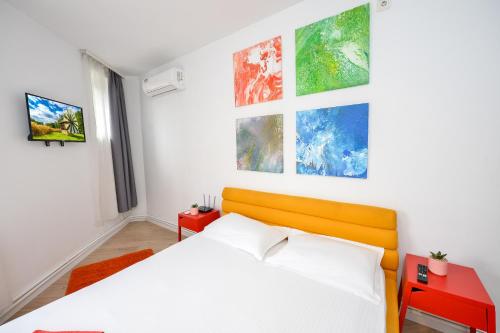 1 dormitorio con 1 cama y pinturas en la pared en Bucharest Nightlife Apartments, en Bucarest