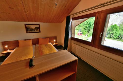 1 dormitorio con 2 camas y ventana en Hotel Wetterhorn, en Grindelwald