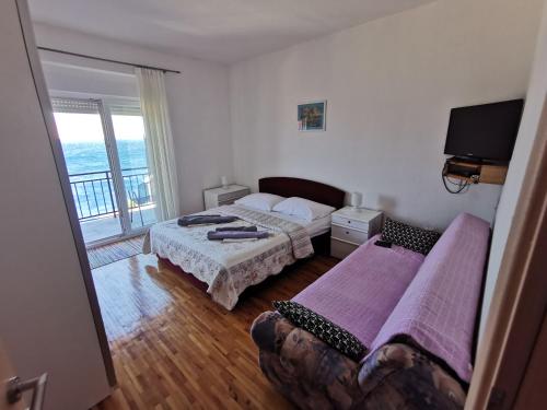 a bedroom with two beds and a balcony at Apartments Lucic in Senj