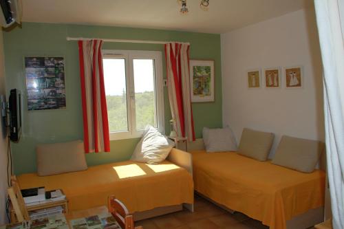 sala de estar con 2 camas y ventana en Appartement les Balcons d'Azur, en Vernègues