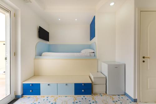 a small room with a bunk bed and blue cabinets at Il Poeta in Procida
