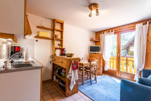 - une cuisine avec un évier et une table dans une chambre dans l'établissement OREE DES PISTES 18, à Morzine