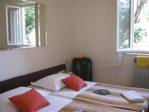 een slaapkamer met een bed met rode en witte kussens bij Apartments and Rooms Artemida in Dubrovnik