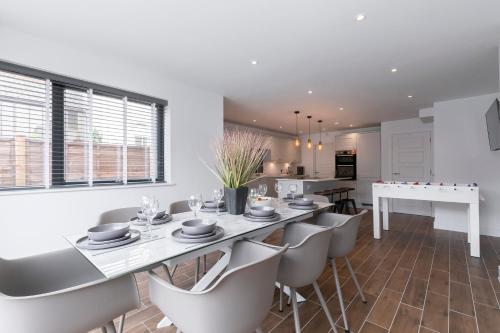 a kitchen and dining room with a table and chairs at Elliot Oliver - The Old Surgery - Stunning 4 Bedroom Home With Parking In Cheltenham in Cheltenham