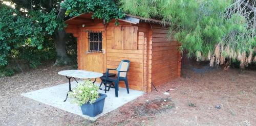 a table and chairs in front of a small cabin at Villa Soroni in Soroni
