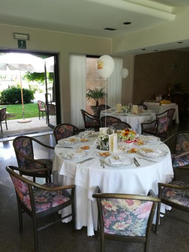 a dining room with tables and chairs with food on them at Villa Cavour in Bottanuco