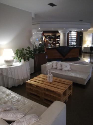 a living room with white couches and a coffee table at Villa Cavour in Bottanuco
