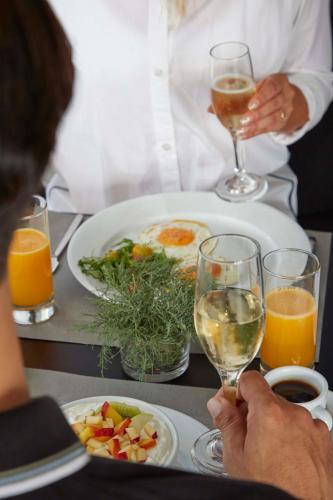 a man sitting at a table with a plate of food and drinks at Mr and Mrs White Oia - Santorini in Oia