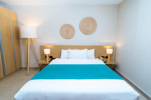 a bedroom with a large bed and two lamps at Redcon Suites in Hurghada