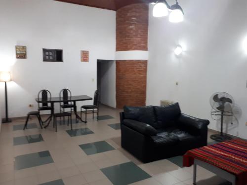 a living room with a black chair and a table at Hermosa Casita II Paso Patria in Paso de la Patria