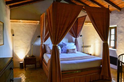 a bedroom with a canopy bed with curtains at Château de Bagnols in Bagnols