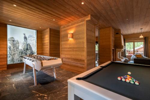 a living room with a fireplace and a large bed at Le Chalet Blanc Hôtel & Spa in Montgenèvre