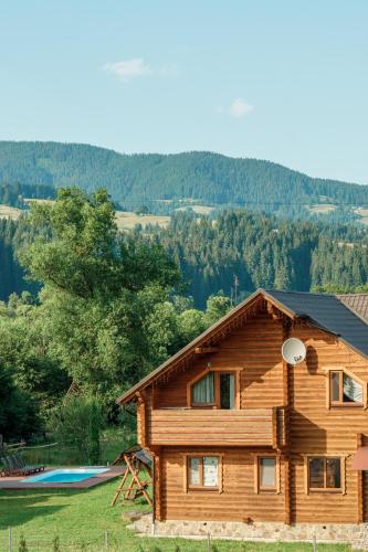 a log house with a playground in front of it at Вілла Софі in Verkhovyna