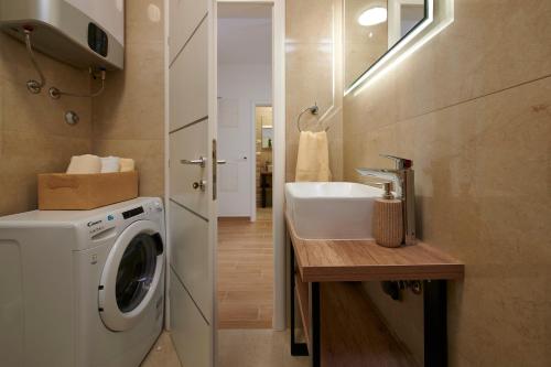 a bathroom with a sink and a washing machine at Apartments Antica Trogir in Trogir