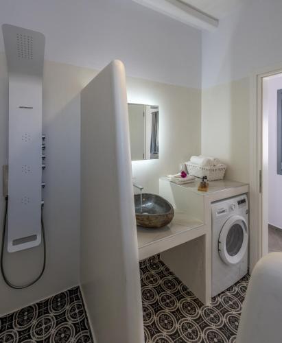 a bathroom with a sink and a washing machine at Zeus Suite in Triovasálos
