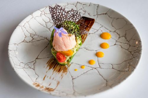a plate of food on a table with oranges at Hotel Leda Spa - Adults Only in Kołobrzeg