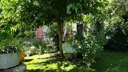 ValaurieにあるECOLE DES GRANDSの木の下にテーブルと椅子のある庭園