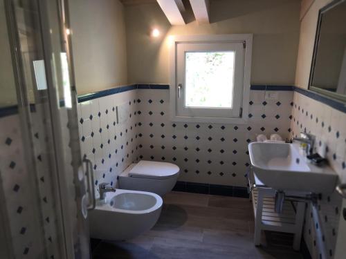 a bathroom with two sinks and a toilet and a window at Camere Toni in Vernazza