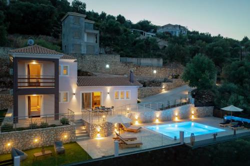 a villa with a swimming pool at night at Koumaries Villas in Lygia