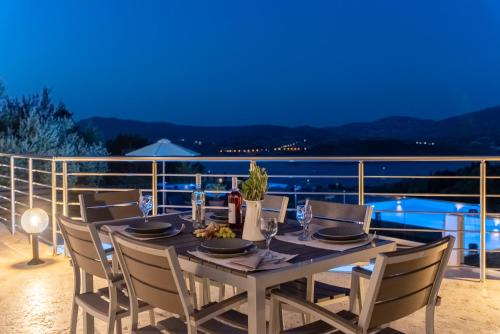 a dining table on a balcony with a view of the ocean at Koumaries Villas in Lygia