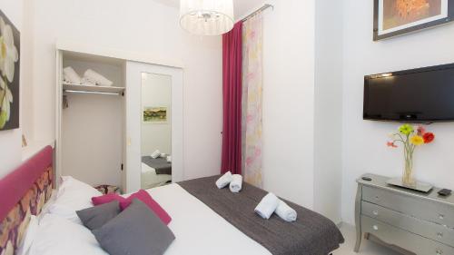 Schlafzimmer mit einem Bett, einem TV und einer Kommode in der Unterkunft Consulta By Rental In Rome in Rom