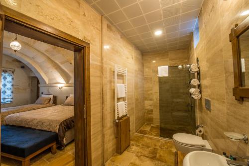 a bedroom with a bed and a bathroom with a shower at Lucky Cave Hotel Cappadocia in Goreme