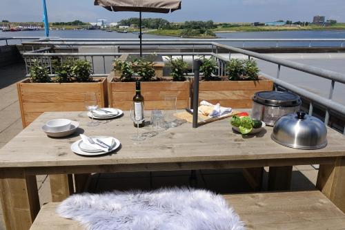 a table on a balcony with a bottle of wine at Dock Hotel Stellendam in Stellendam