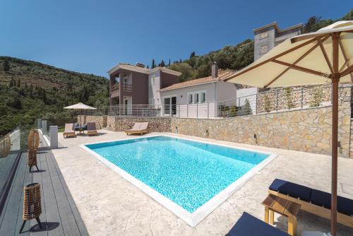 a villa with a swimming pool and a house at Koumaries Villas in Lygia