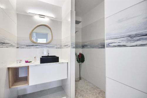 une salle de bain avec un lavabo et un miroir dans l'établissement Villa Lili, à Les Trois-Îlets