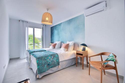 une chambre avec un lit et une table avec une chaise dans l'établissement Villa Lili, à Les Trois-Îlets