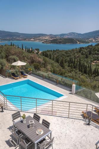 a villa with a swimming pool and a table at Koumaries Villas in Lygia