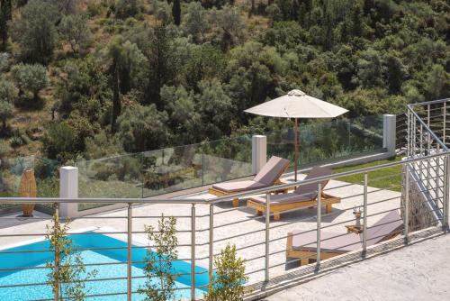 a villa with a swimming pool and an umbrella at Koumaries Villas in Lygia