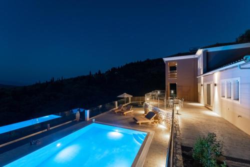 a house with a swimming pool at night at Koumaries Villas in Lygia