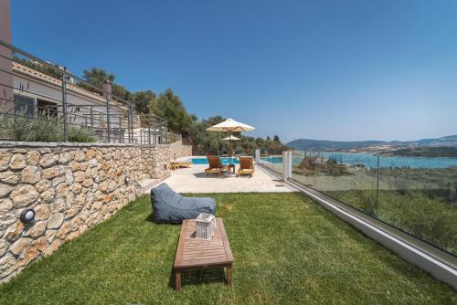 a backyard with a table and a stone wall at Koumaries Villas in Lygia