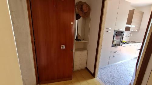 グラードにあるLuogo di Paceの木製のドア、白い冷蔵庫付きのキッチンが備わります。
