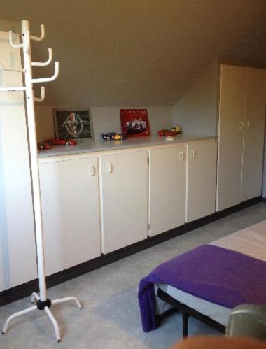 a room with white cabinets and a table in a room at Chez nous. in Couvin