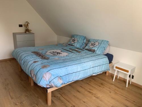 1 dormitorio con 1 cama con edredón azul en Vacanzamare, en Wenduine