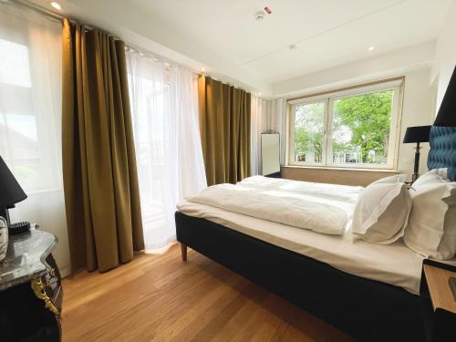 sypialnia z dużym łóżkiem i oknem w obiekcie Staffanstorps Gästis Hotell w mieście Staffanstorp