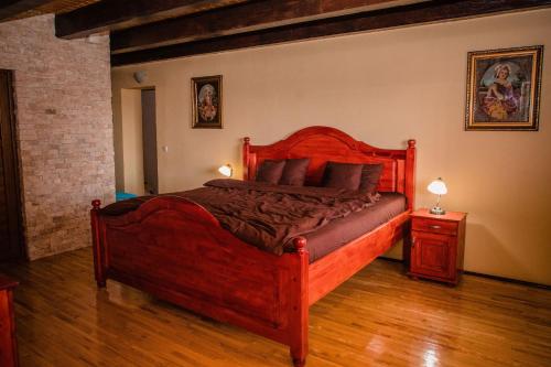 1 dormitorio con cama de madera en una habitación en Vila Izvoarele, en Izvoarele