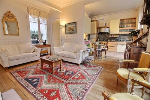 - un salon doté d'un mobilier blanc et d'un tapis dans l'établissement 207535 - Appartement 4 personnes Champ de Mars, à Paris