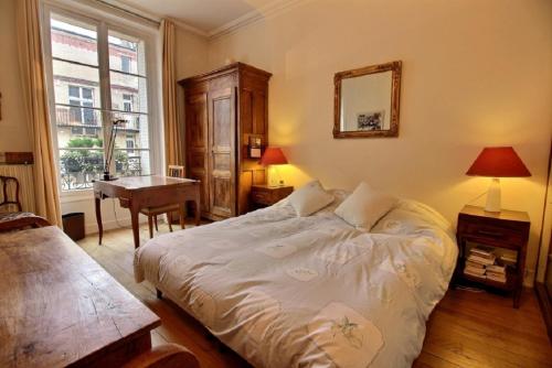 une chambre avec un lit, un bureau et une fenêtre dans l'établissement 207535 - Appartement 4 personnes Champ de Mars, à Paris