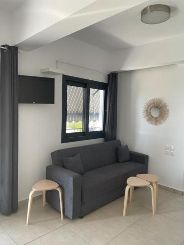 a living room with a couch and two stools at Pargas paradise in Parga