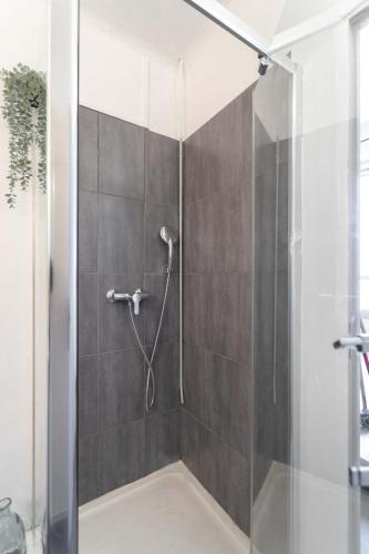 une douche avec une porte vitrée dans une salle de bain dans l'établissement Le Rive Neuve Standing Vieux-Port - Appartement 1 chambre 4 pers Vue Mer Clim, à Marseille