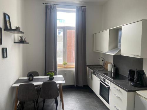 a kitchen with a table and chairs and a window at Haus Alf in Wilhelmshaven