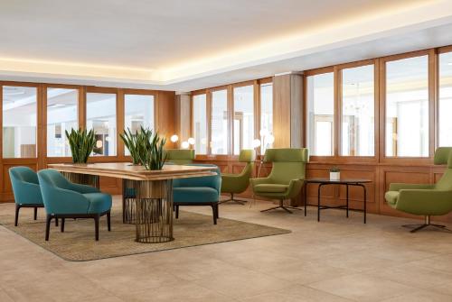 a waiting room with a table and chairs at Park Hotel Casimiro in San Felice del Benaco