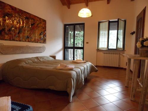 una camera con un letto in una stanza con finestre di Antica Dimora del Portico a Borgiallo