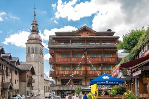 a large building with a clock tower in a city at Best Western Chalet les Saytels in Le Grand-Bornand